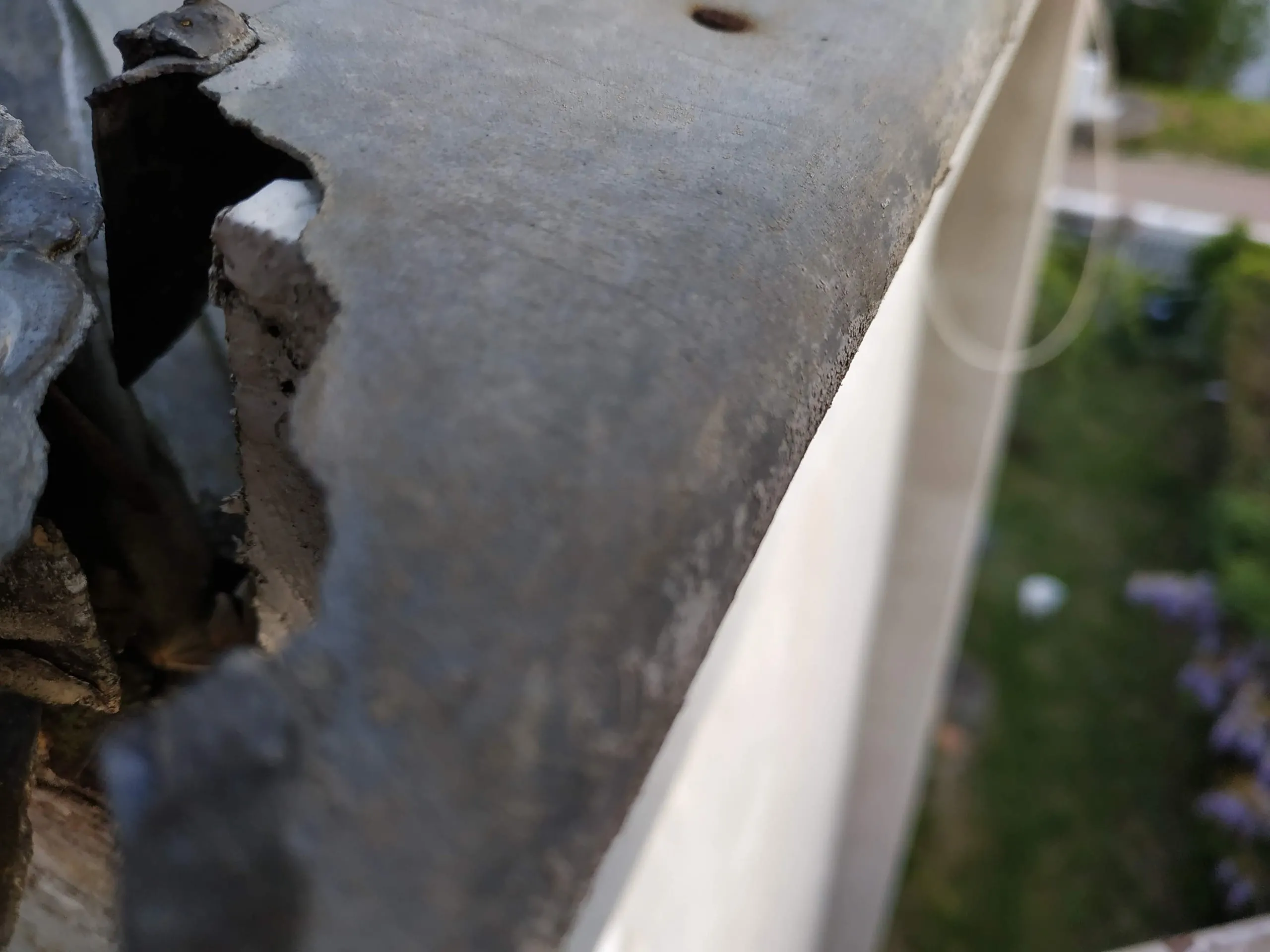 Détail d’une gouttière et du bord d’une toiture avec élément de zinguerie gris
