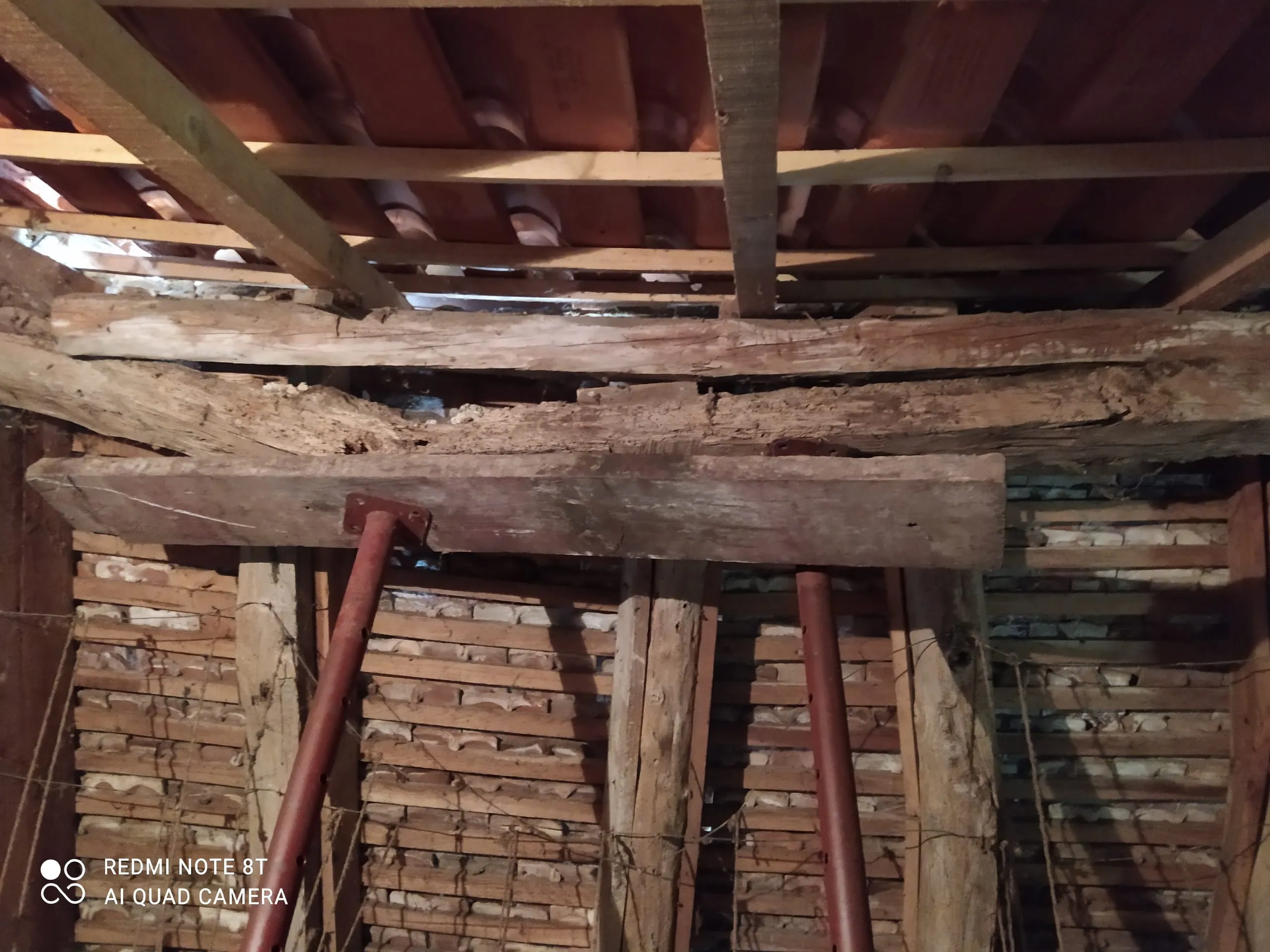 Bois anciens soutenus par des étais sous une couverture en tuiles