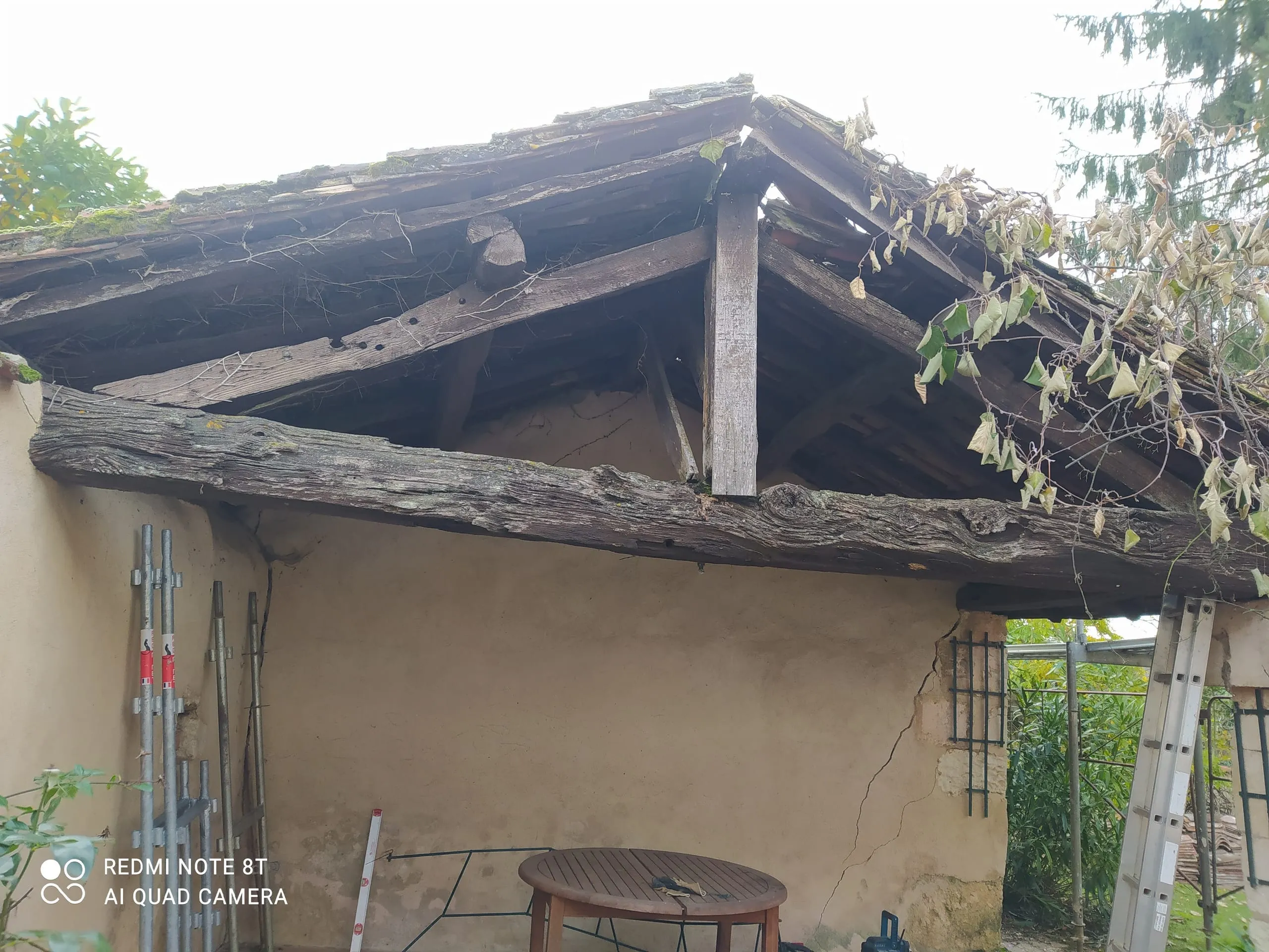 Ancienne charpente en bois avec poutres apparentes sous une toiture vieillie