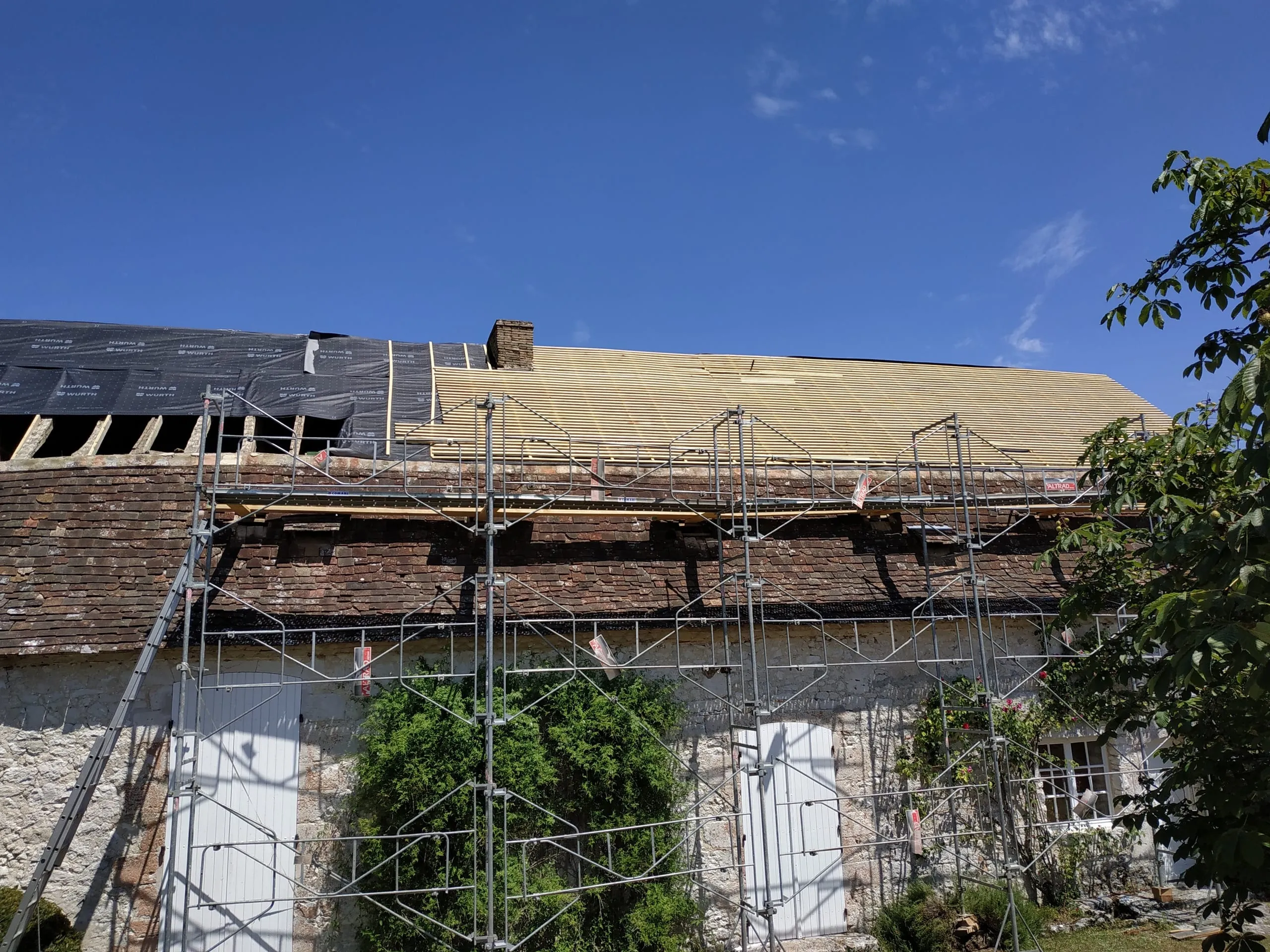 Rénovation d'une toiture ancienne avec pose de l'écran sous-toiture et des liteaux.