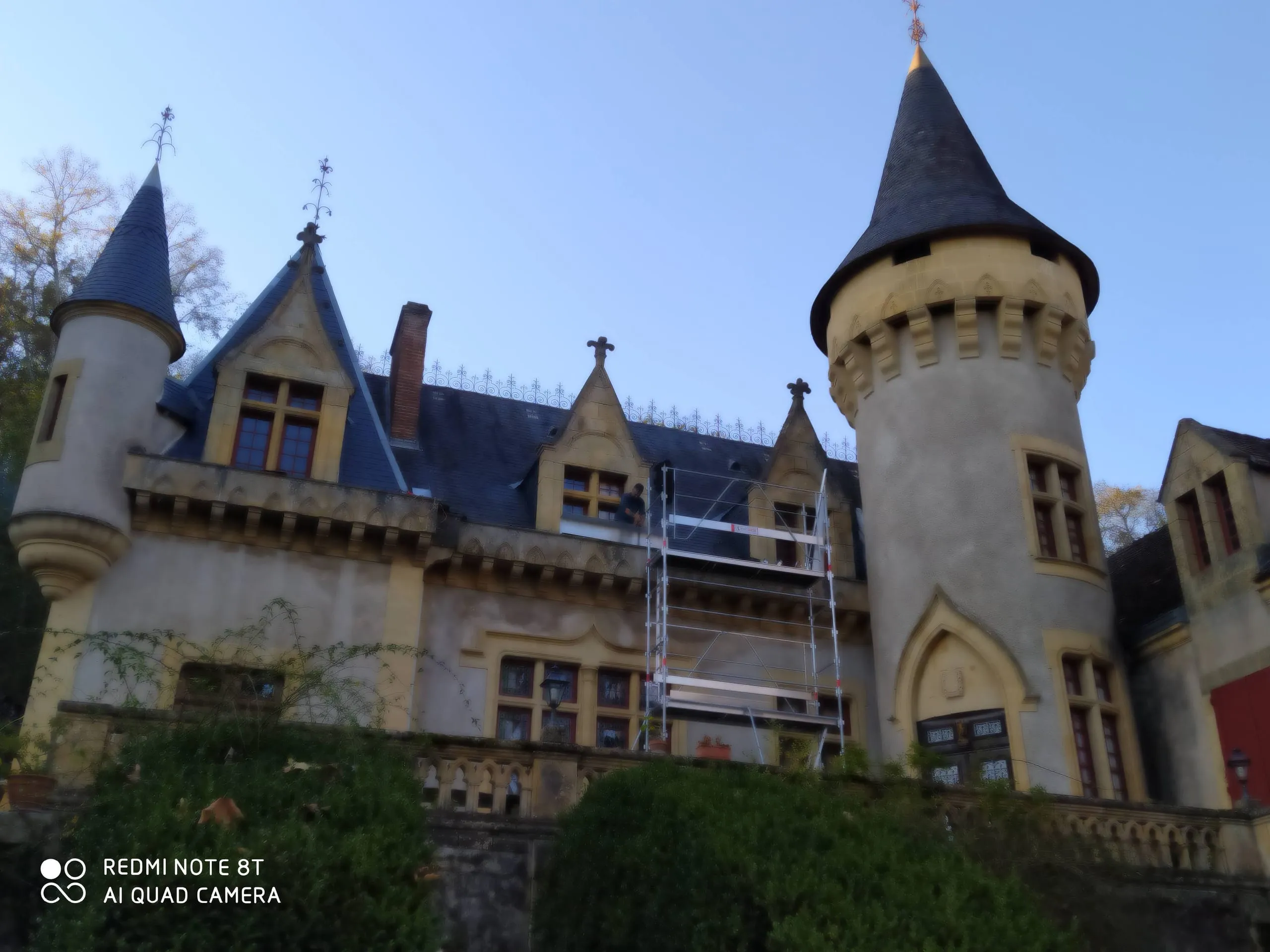 Rénovation d’une toiture en ardoise sur un château avec échafaudage.
