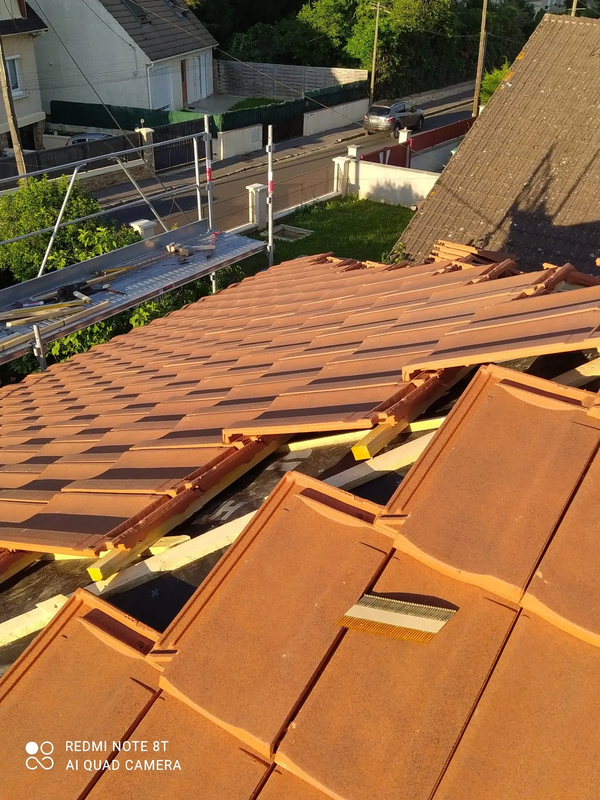 Toiture en tuiles terre cuite en cours de rénovation, avec échafaudage et éléments déposés