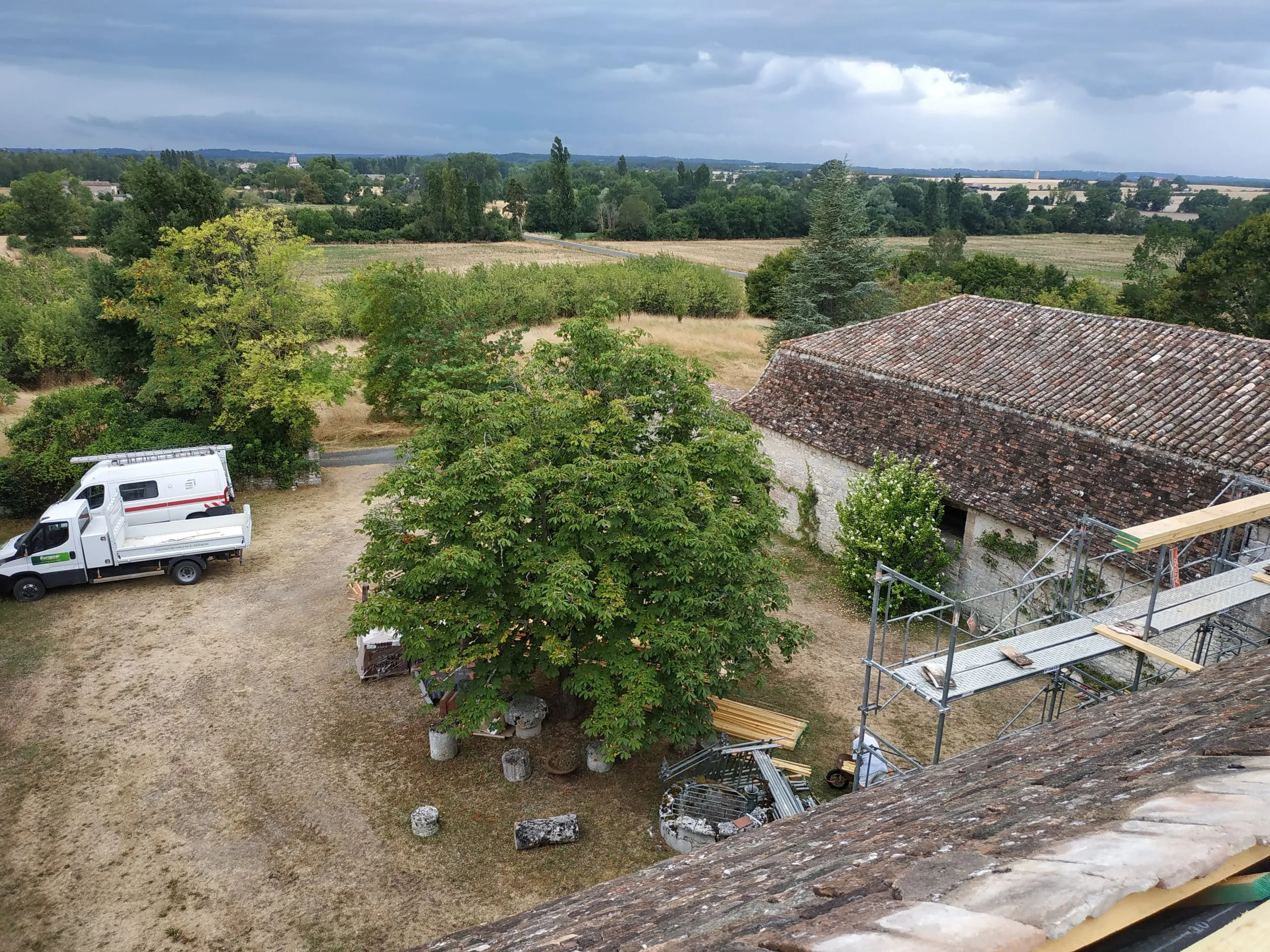 Toiture ancienne en tuiles près d’un échafaudage et de matériaux de couverture