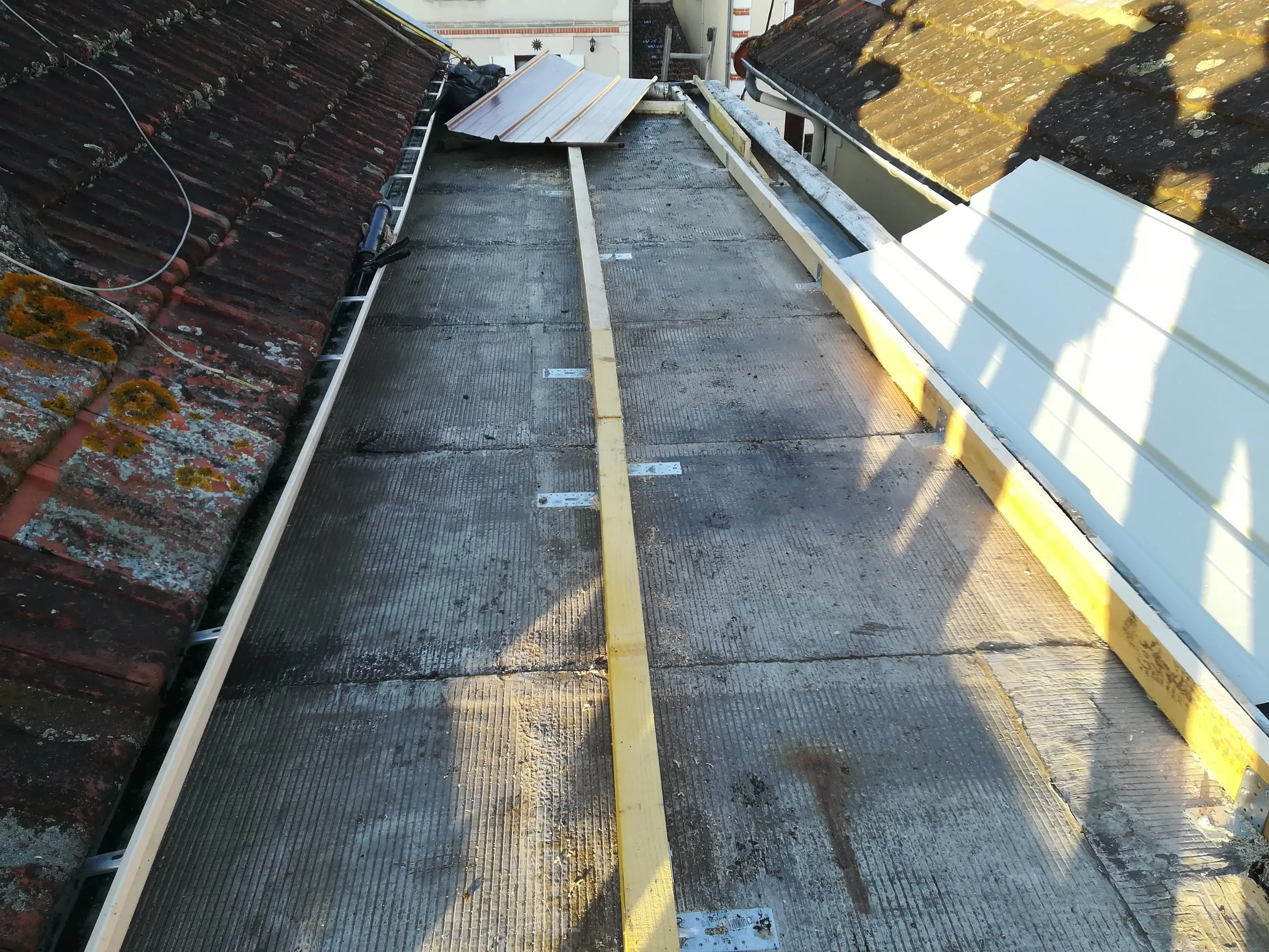 Toiture en rénovation avec supports de couverture et éléments métalliques de zinguerie