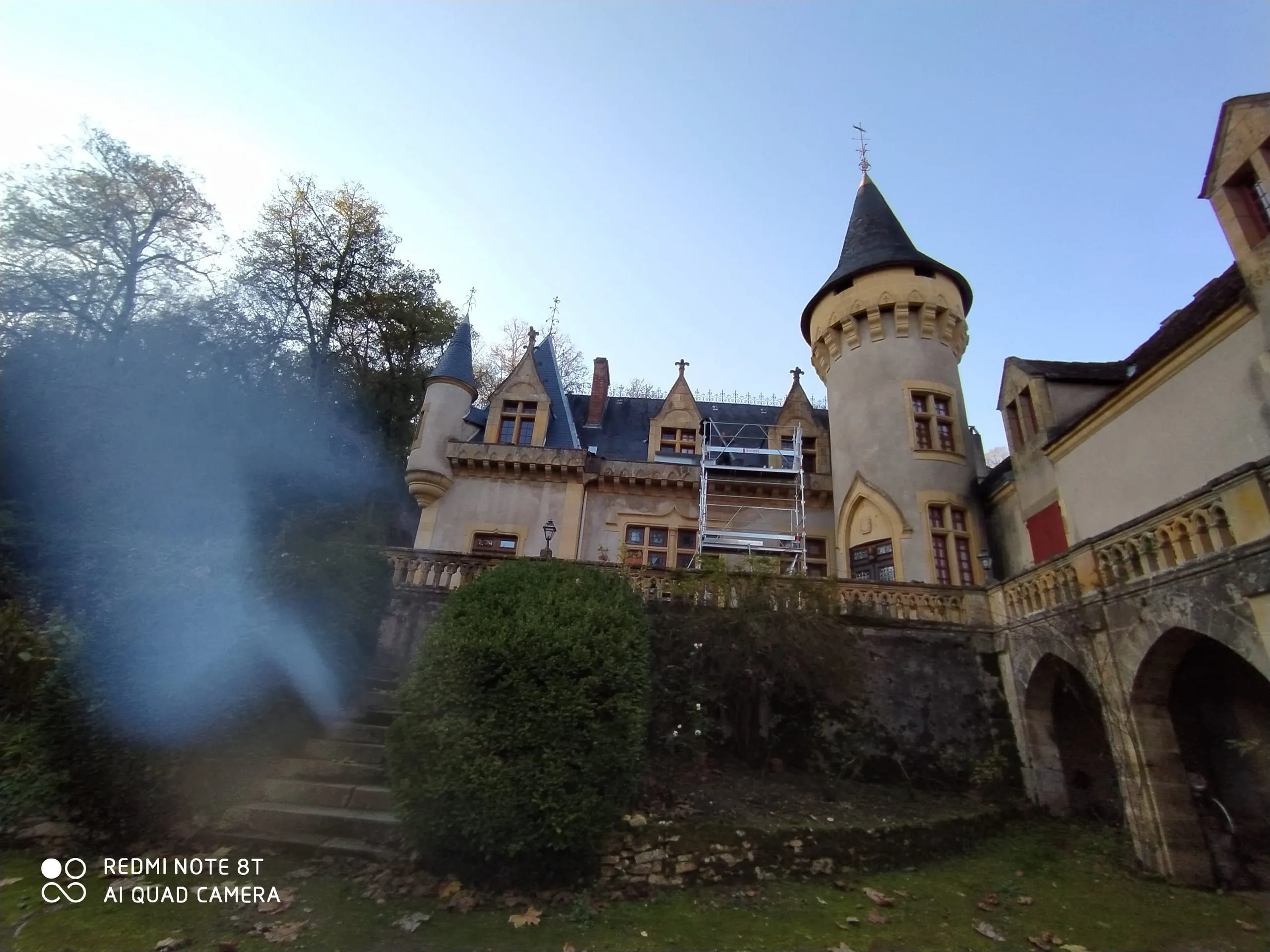 Bâtisse à tourelles avec toiture en ardoise et échafaudage devant la façade