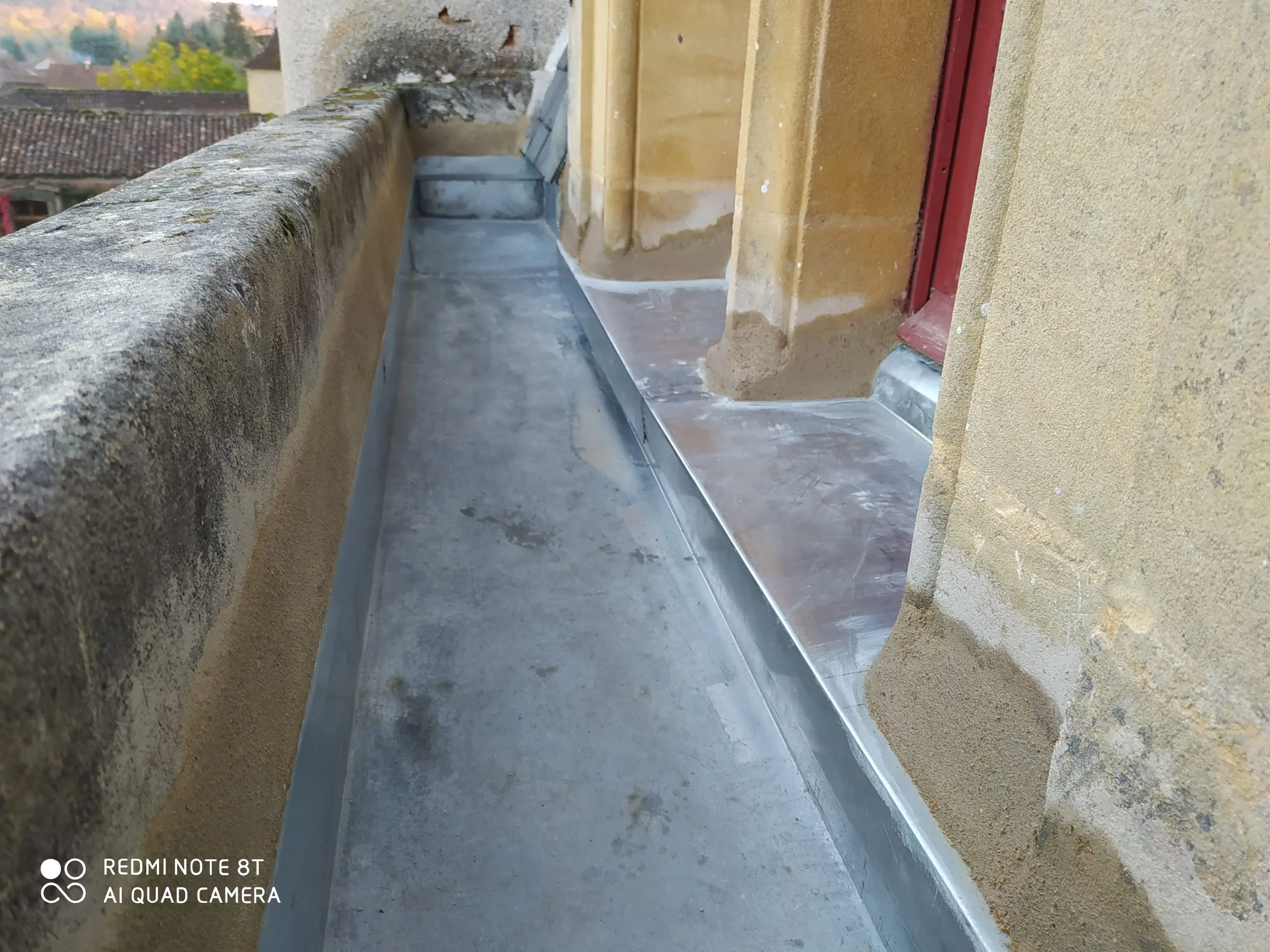 Raccord de zinguerie en zinc le long d’un mur et autour de maçonneries anciennes